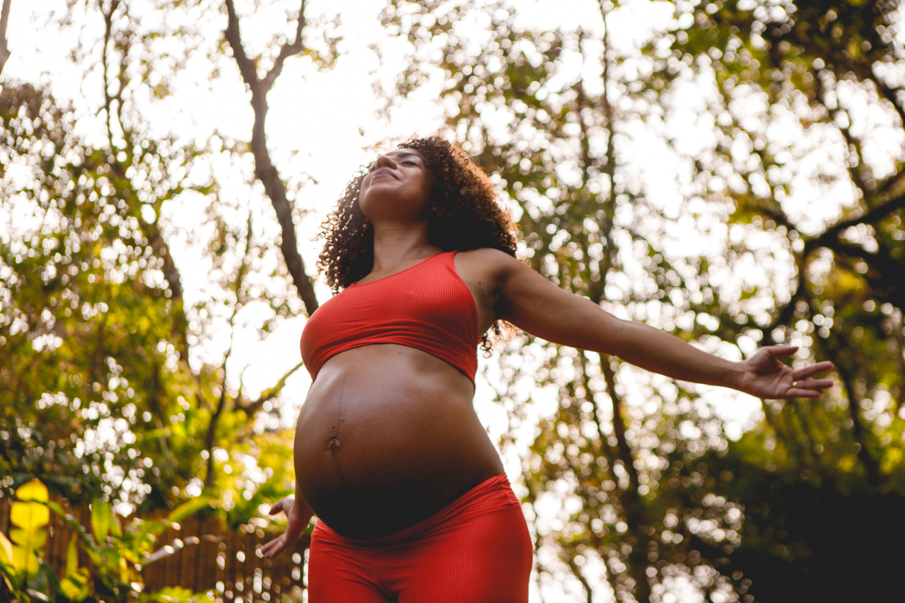 A young pregnant woman happily relaxes with pre-natal yoga.