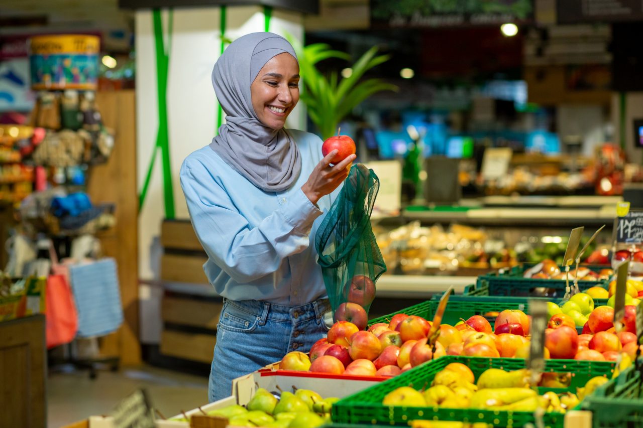 Health lady in a headscarf shops for for fruits and vegetables.