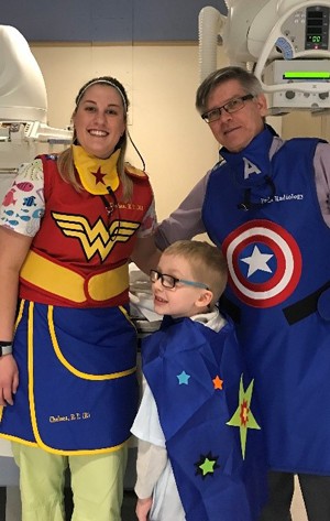Pediatric patient with care team dressed as super heros