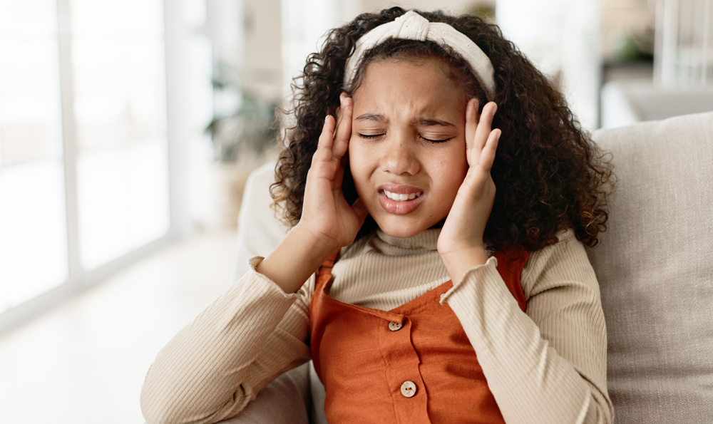 A child holding her head
