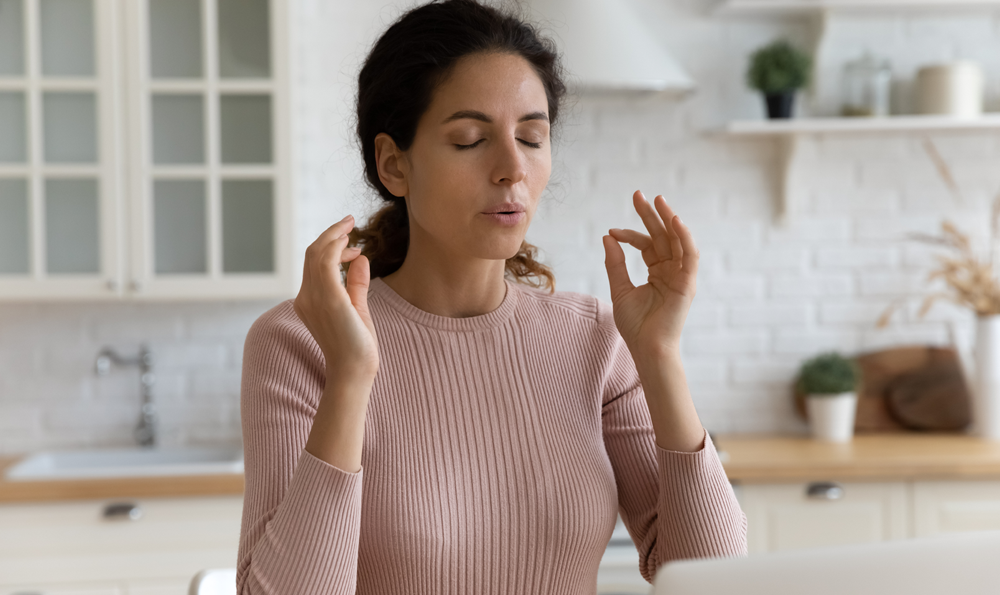 Woman practices mindfulness in her kitchen.