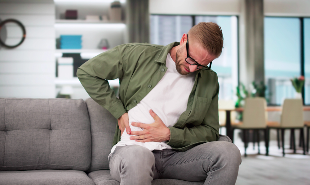A man in pain holding his torso.