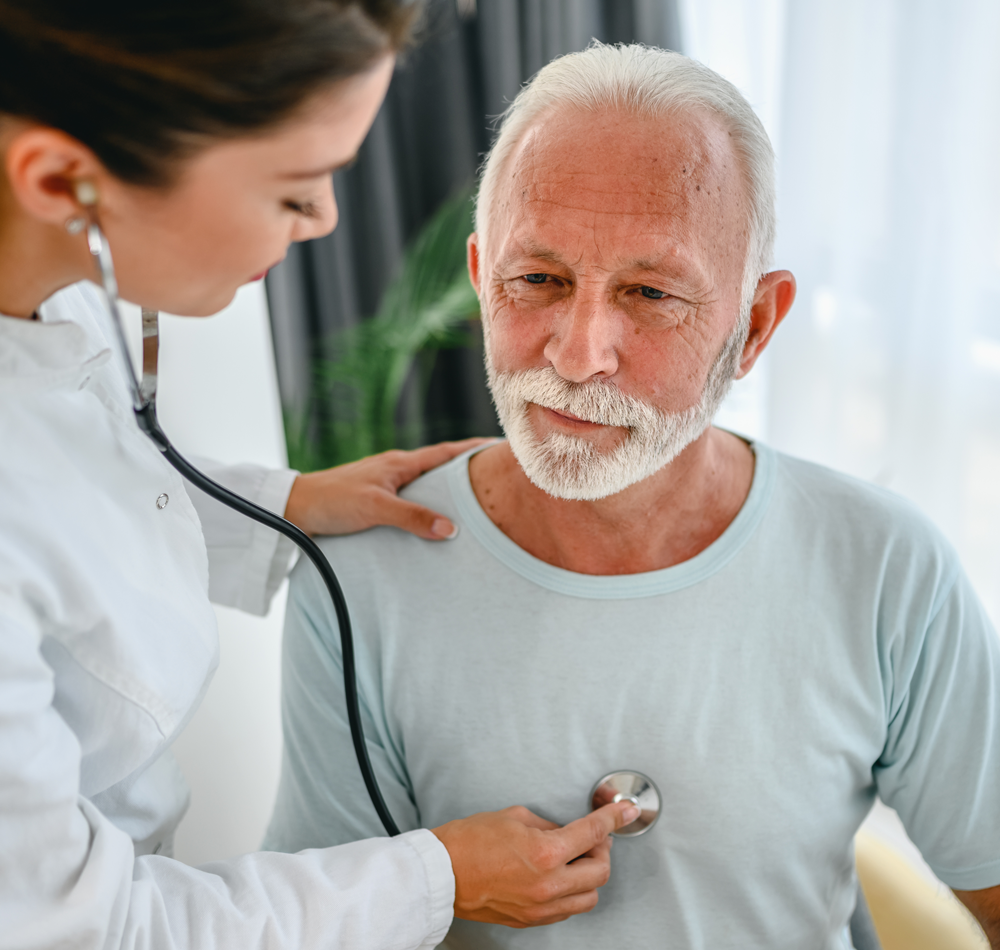 mature man having his heart listened to by female doctor