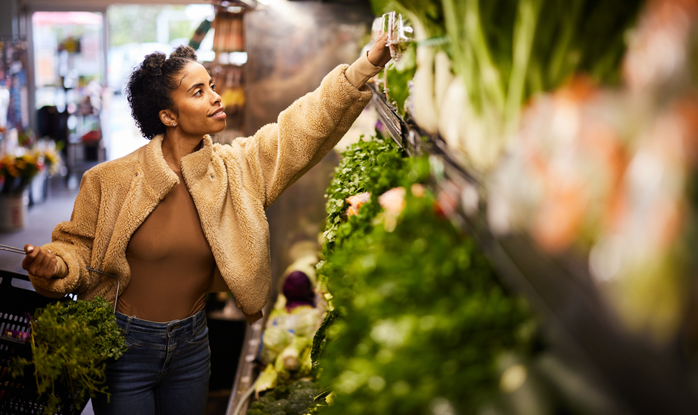 A woman picking vegetables in a market