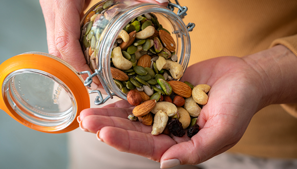 Person pouring trail mix into their hand is shown.