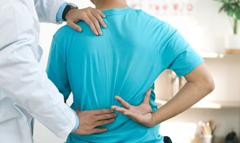A patient's spine being assessed by a physician
