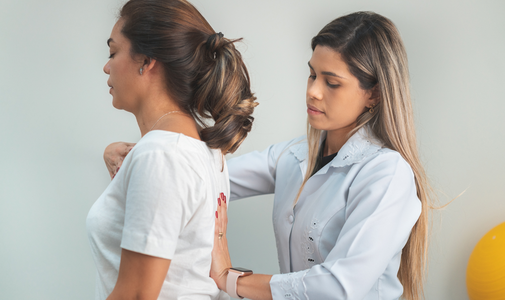 Physical therapist helping woman with good posture