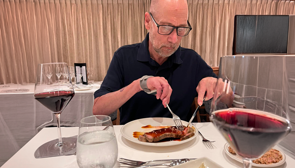 Kevin cutting his steak at a restaurant in France. 