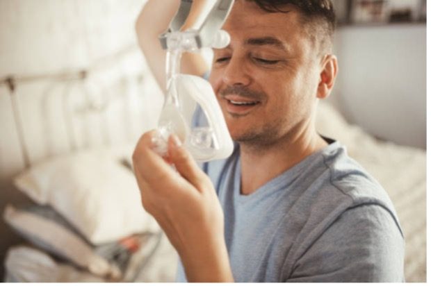A man putting on an oxygen mask.
