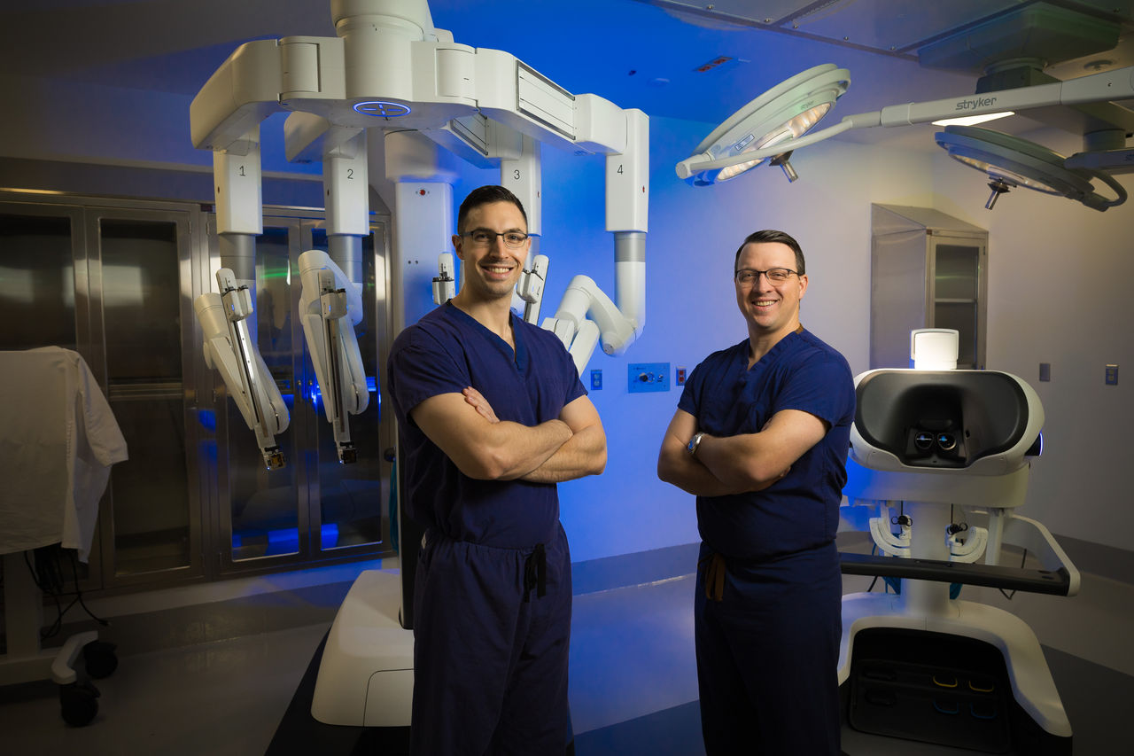 Hernia doctors stand in front of an advanced technology surgical robot.