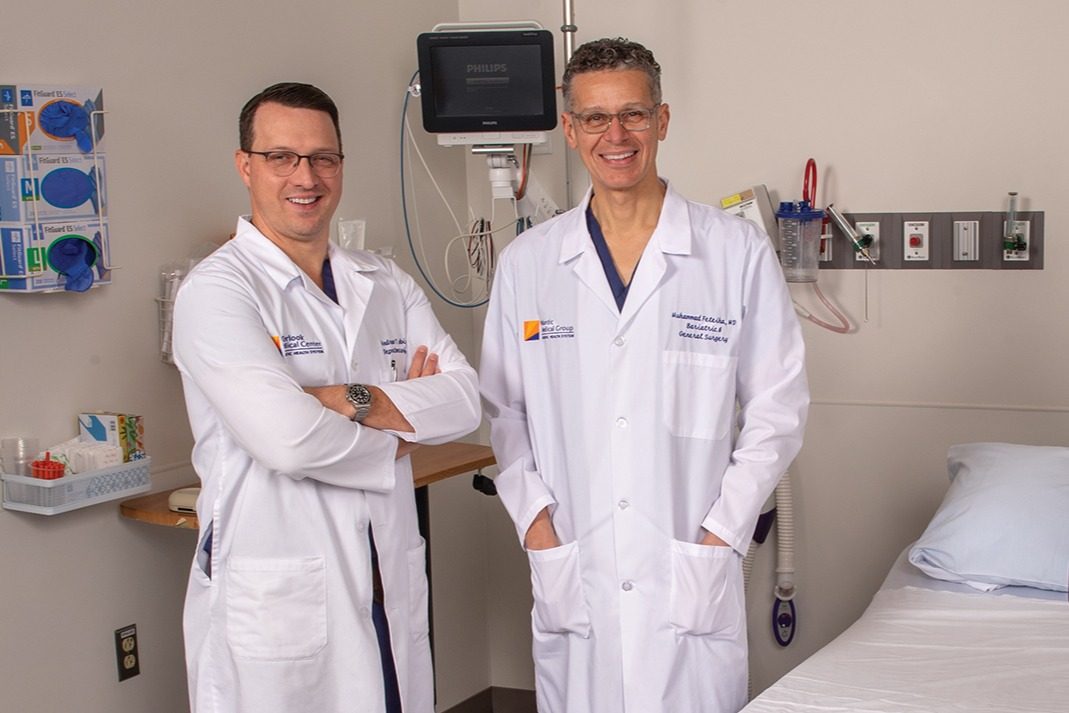 Hernia doctors stand in front of an advanced technology surgical robot.