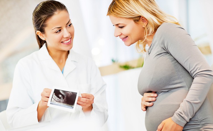 Doctor with pregnant patient looking at a scan