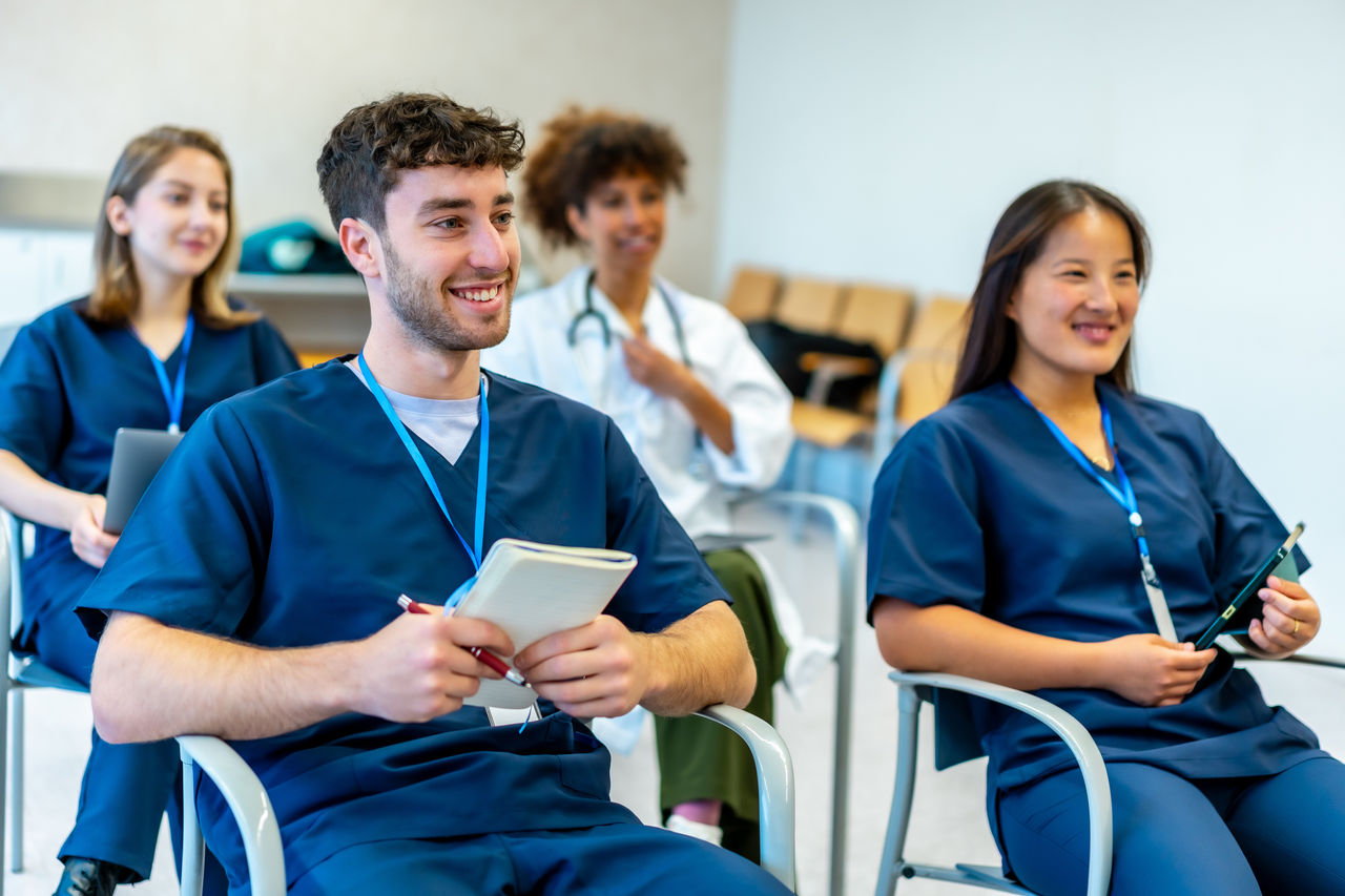 Group of resident doctors sitting in chairs learning.