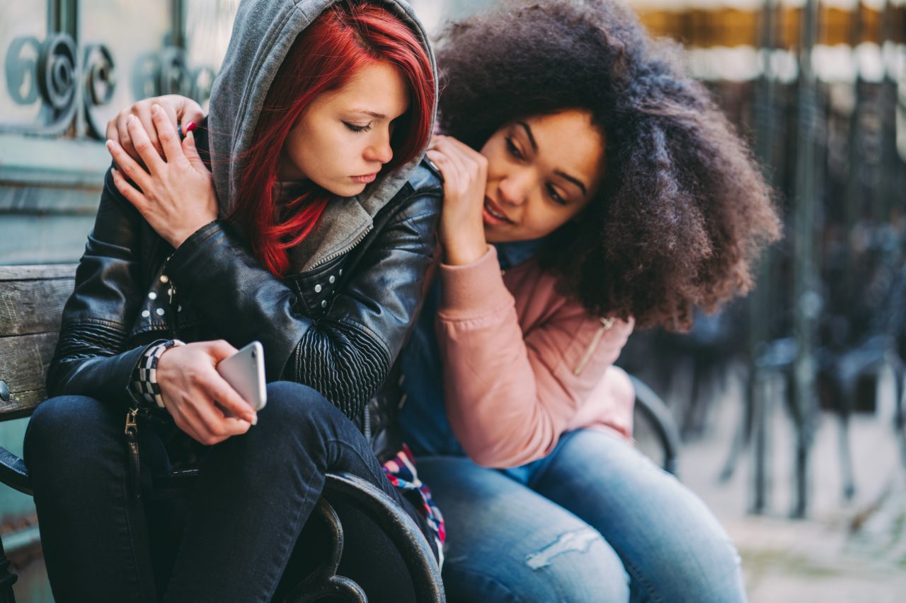 Teen girl comforting a heavily depressed teen girl
